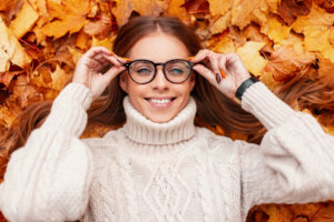 Frau mit Brille liegt im Laub